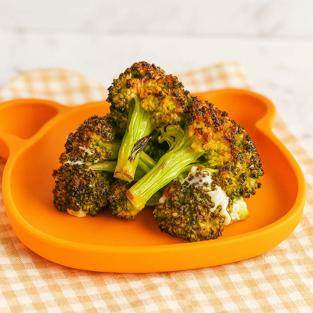 A stack of broiled broccoli for kids shown on a toddler plate.