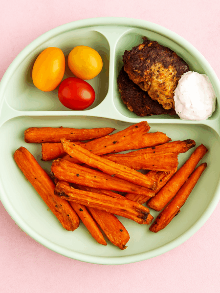 A plate full of carrot fries is shown.