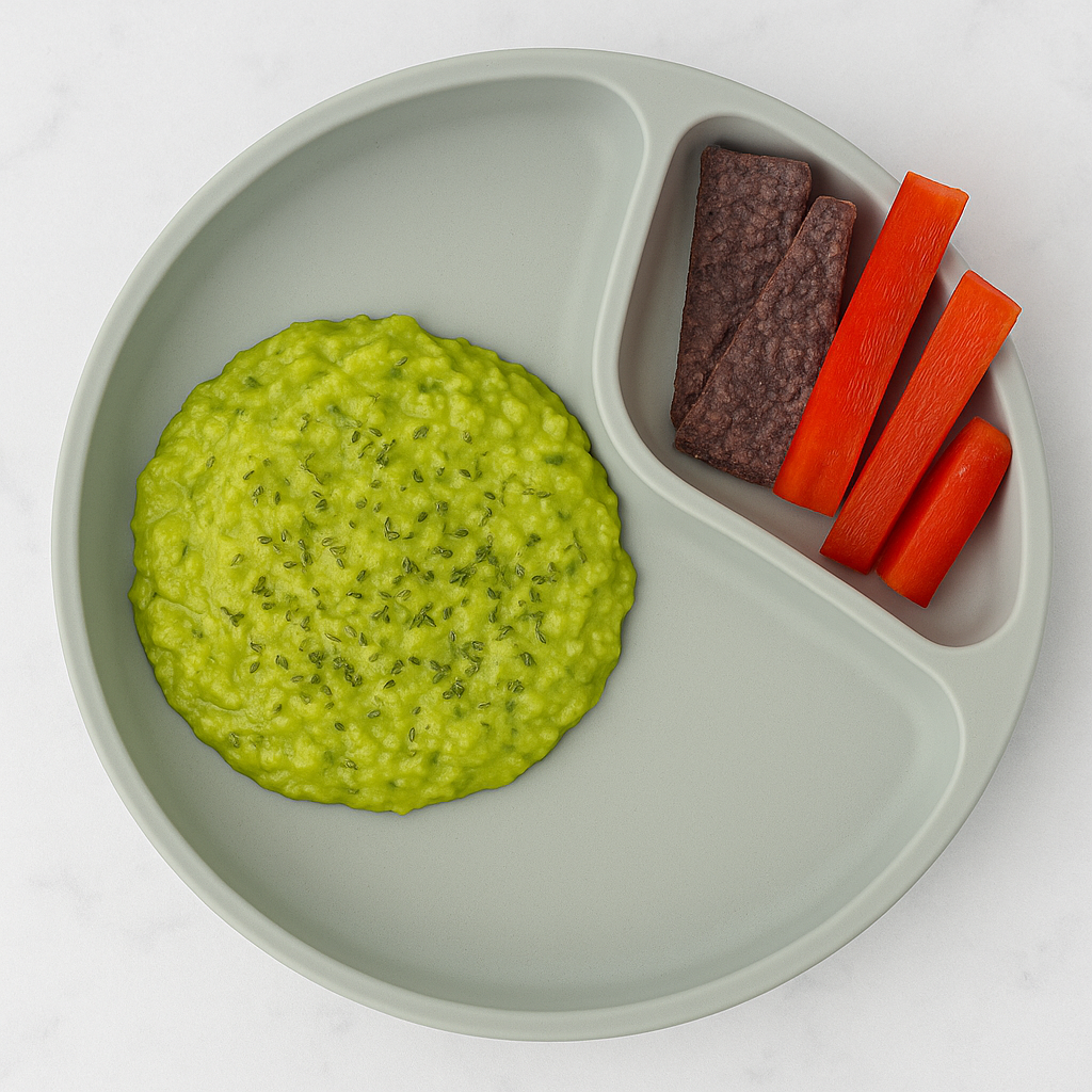 A pool of toddler guacamole is sided by chips and vegetable strips.