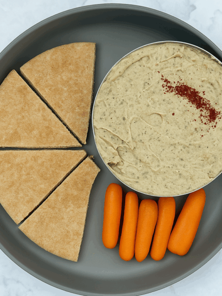 Baba ghanoush for babies, here plated with pita and baby carrot sticks.
