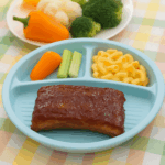 Ribs for kids: it's possible! A set of saucy, fall-off-the-bone ribs are sided with cucumber slices.
