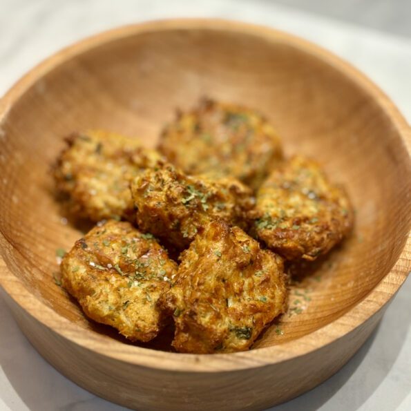 A wooden bowl full of air-fried cauliflower nuggets