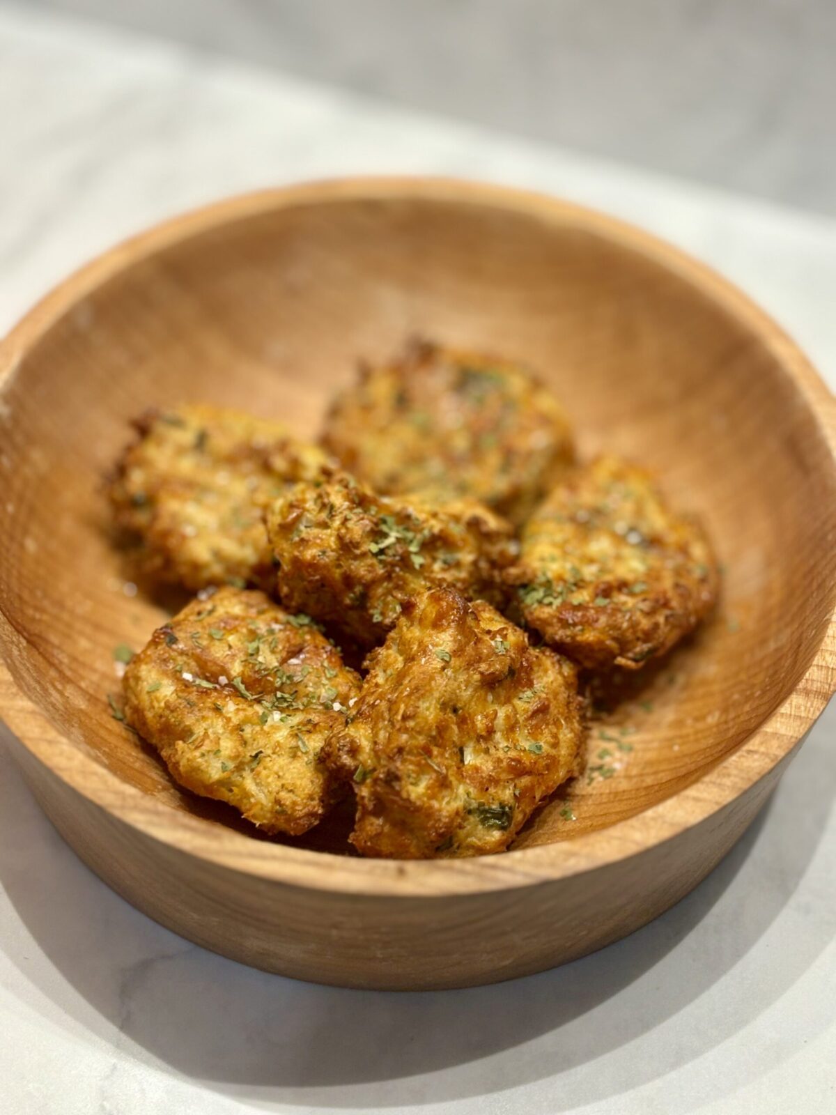 A wooden bowl full of air-fried cauliflower nuggets