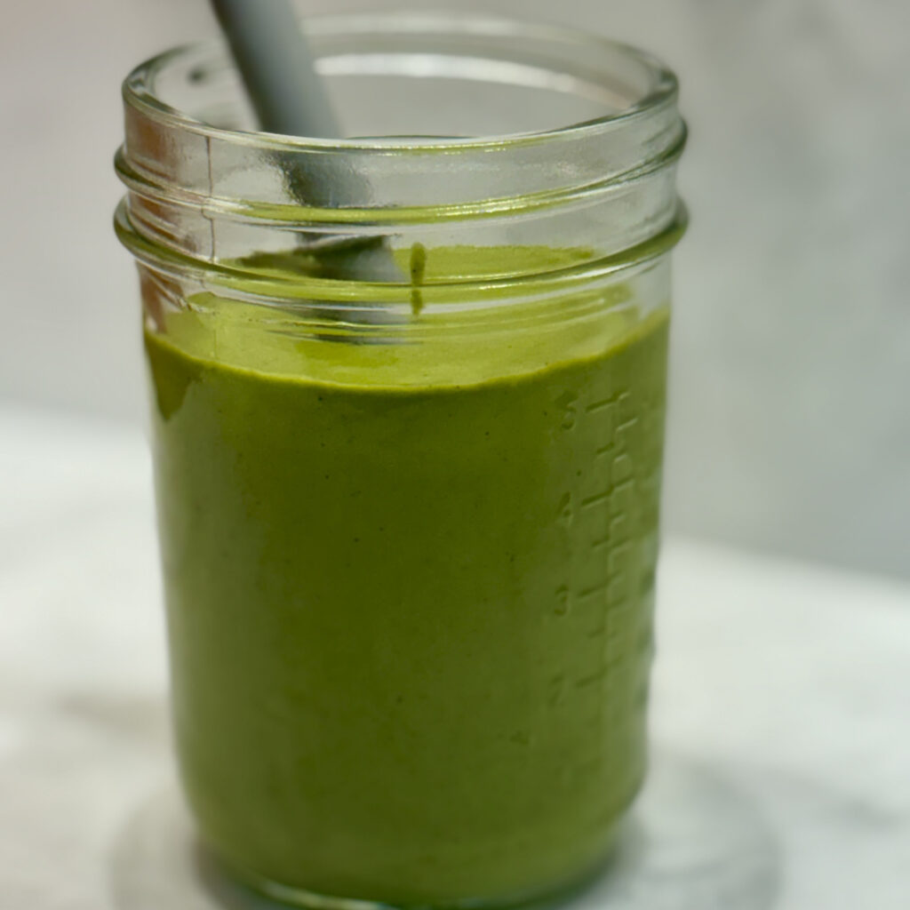 A close-up of a protein smoothie colored green due to the inclusion of kale.