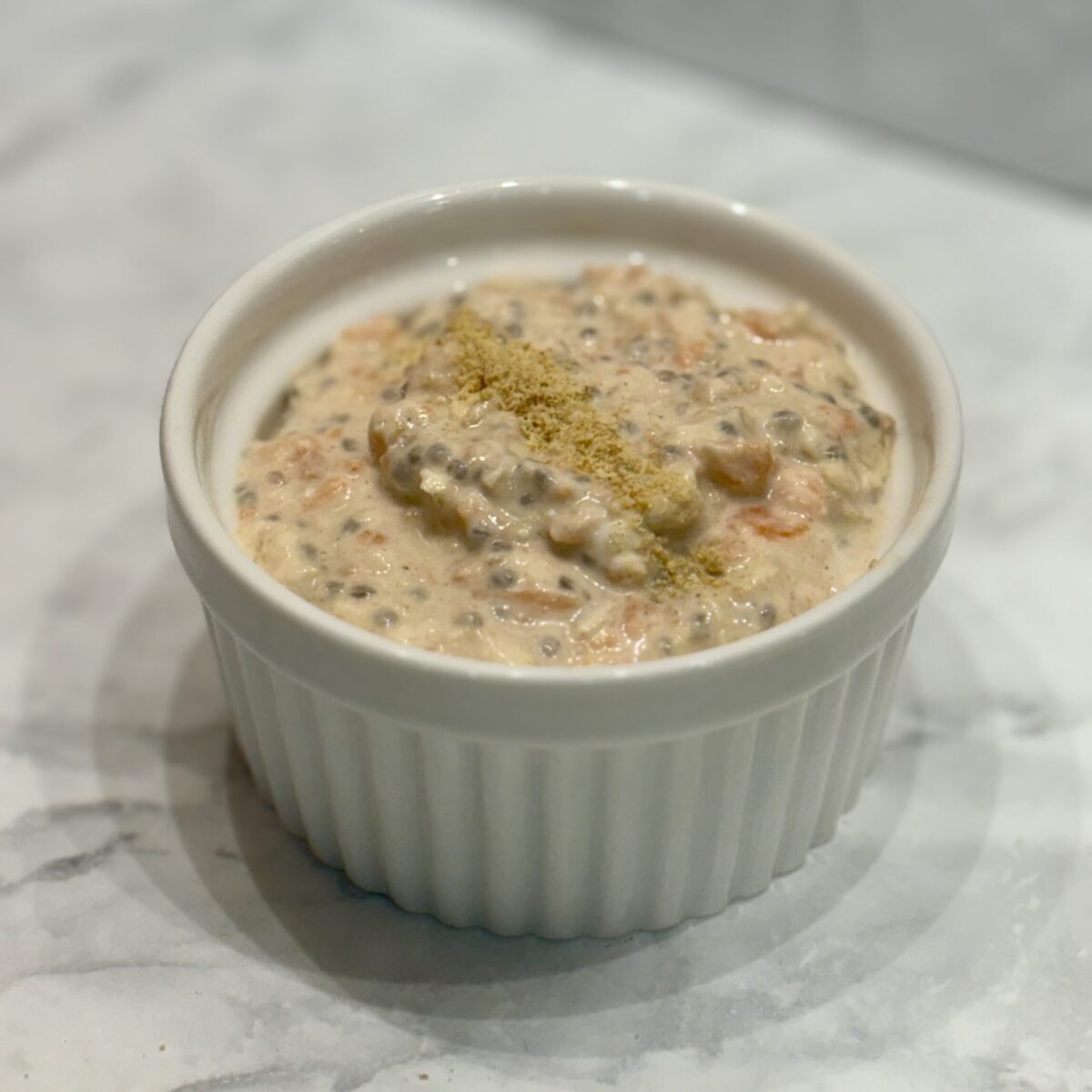 A small ramekin is filled with carrot cake flavored overnight oats.