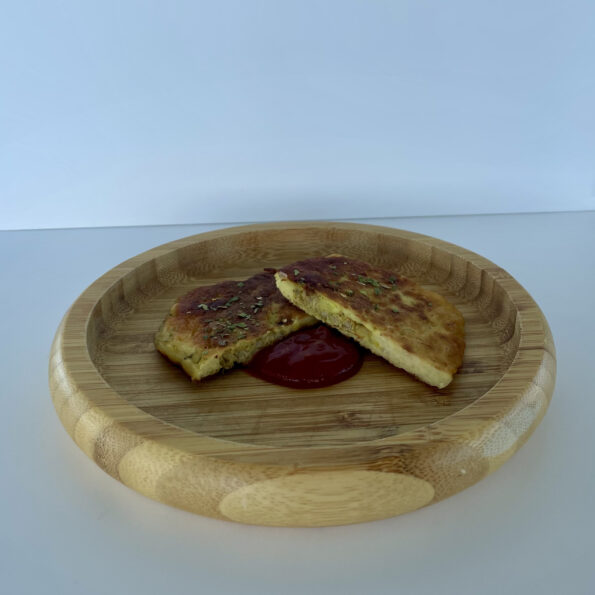 A kid-friendly version of the Iraqi meat pancake known as kubba is served split in half and sided with ketchup.