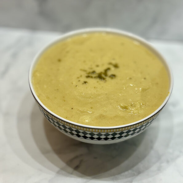 A bowl of corn and cashew chowder is displayed on a counter.