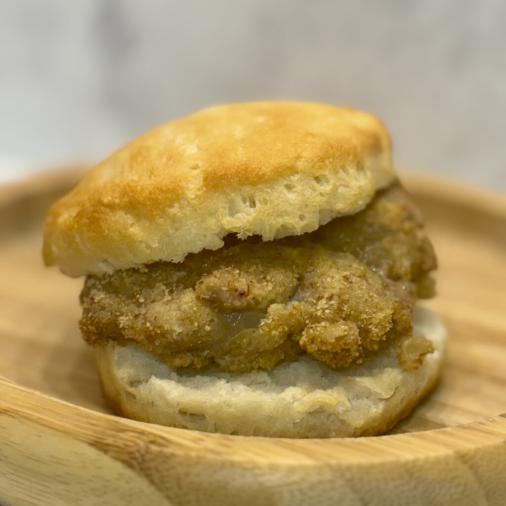 A crispy pork and cauliflower cutlet, known as The Cautlet, is sandwiched between a biscuit.