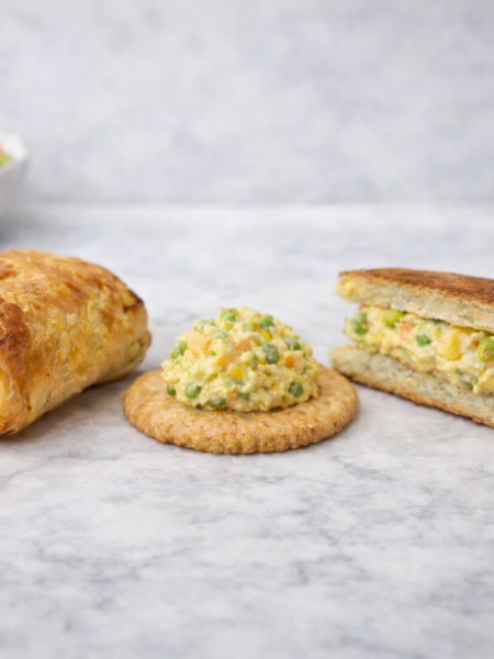 Chicken salad for toddlers, shown three different ways (from left): wrapped inside puff pastry, topping a cracker, and sandwiched between buttered toast points.