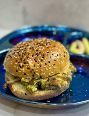 Infant and toddler burger, studded with avocado and black beans, is presented on a bun.