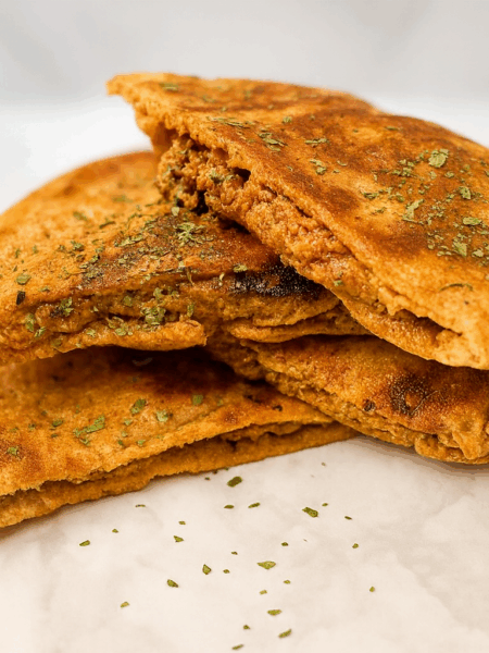 A stack of toddler pita pockets, adapted from a middle eastern dish (hawawshi) known as the "arabic hamburger," shows toasted pita stuffed with a ground beef and vegetable mixture.