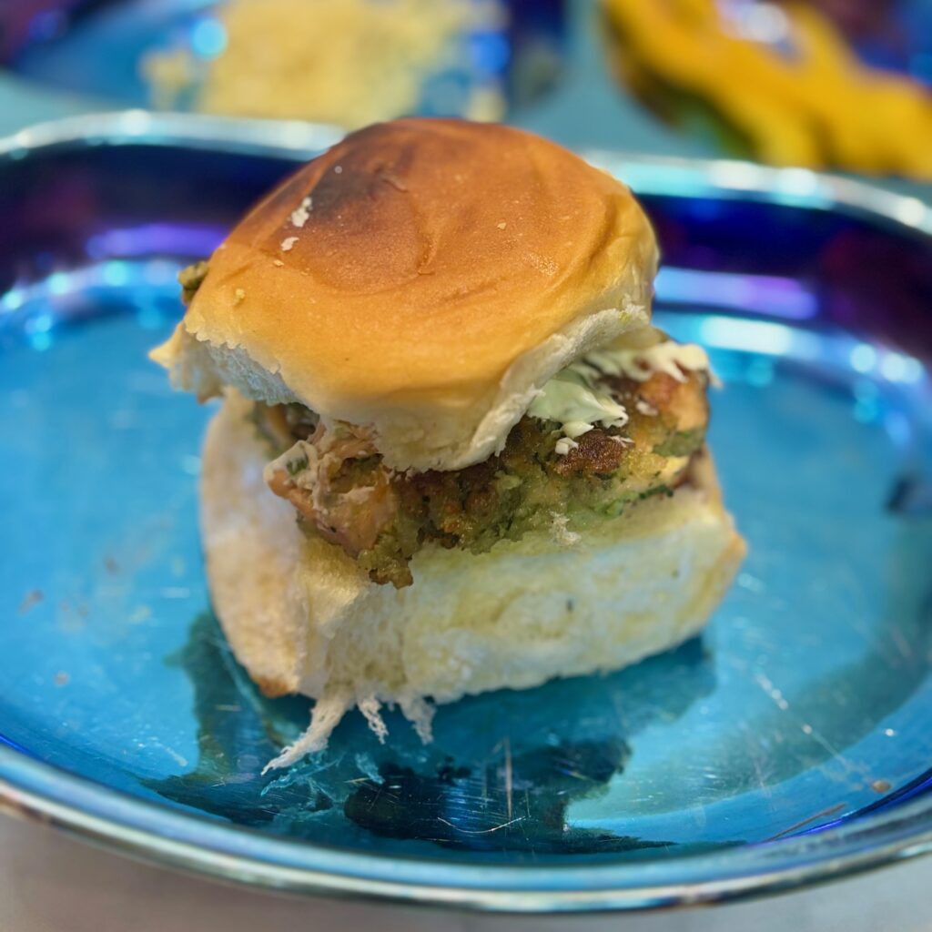 A salmon burger is nestled between slider buns.