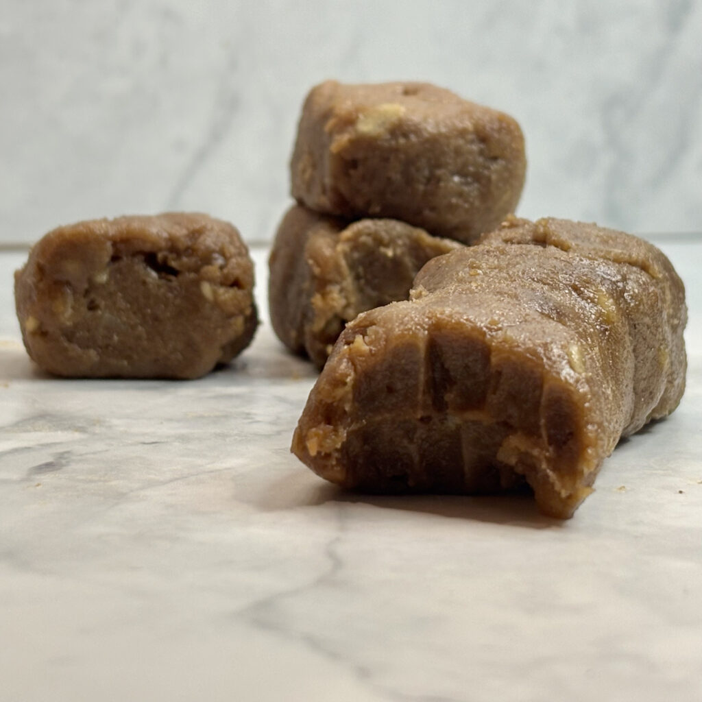 A chocolate, cashew and date flavored toddler energy bar is shown, along with smaller bars of the same kind.