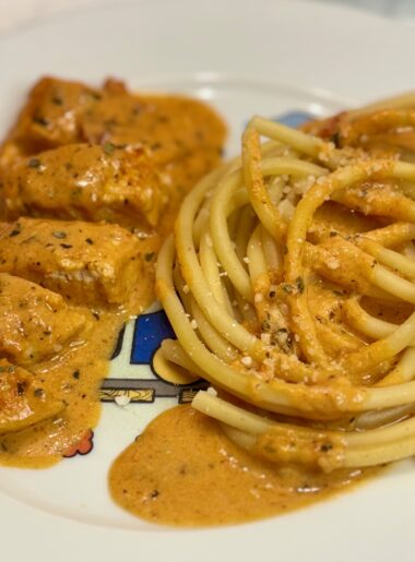 The chicken recipe for kids Marry Me chicken, modified for toddlers, is plated next to spaghetti with the same sauce.