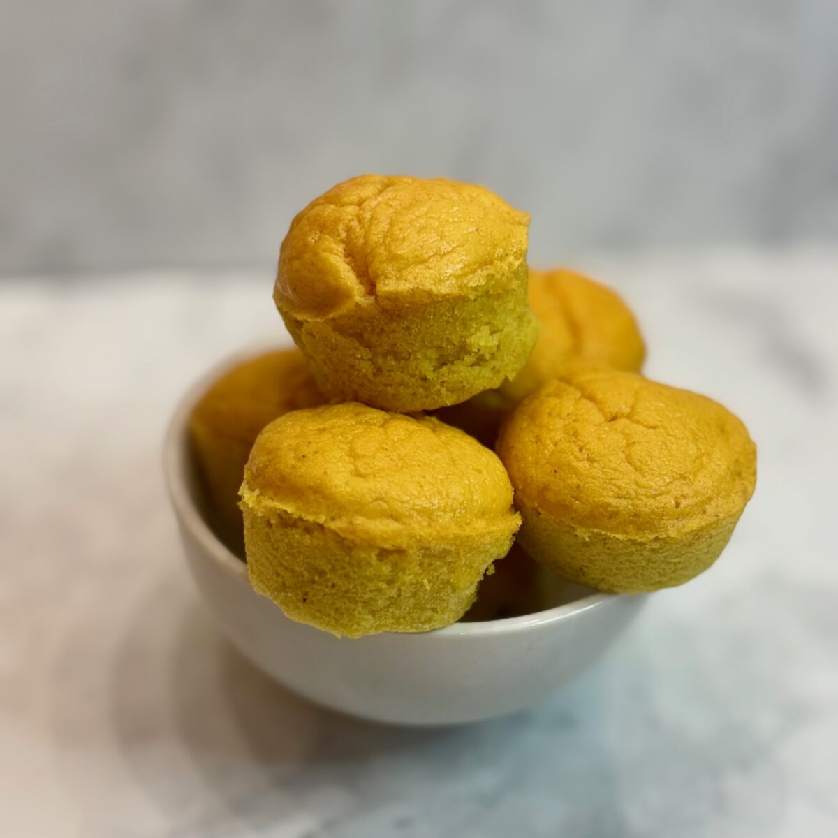 A bowl full of toddler protein muffins is displayed.