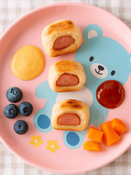 Pigs in the blanket for toddlers features hot dog bits wrapped in mayo and mustard slicked puff pastry.