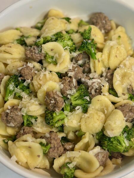 Orecchiette pasta, broccoli, and meatballs are on display in a bowl of an easy pasta recipe for toddlers.