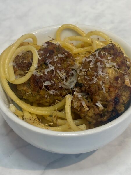 garlicky and cinnamon-y buttered noodles are topped with stuffed meatballs.