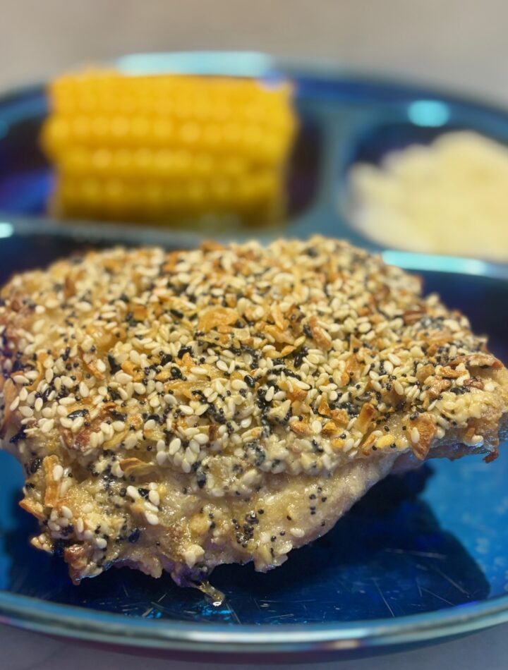 A roast chicken for toddlers is presented studded with everything bagel spice.