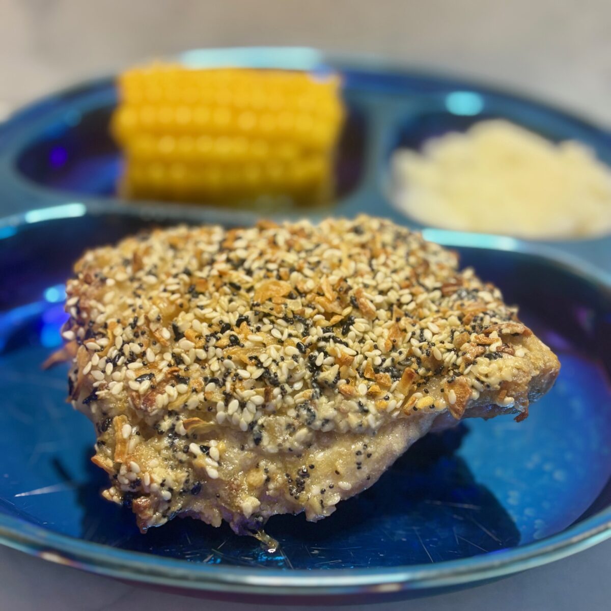 A roast chicken for toddlers is presented studded with everything bagel spice.