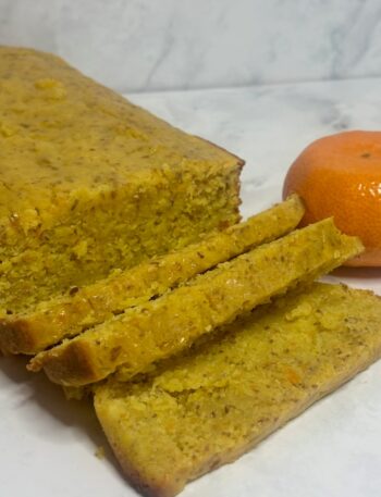 A cake made from leftover clementines is shown in loaf form, with some slices cut.