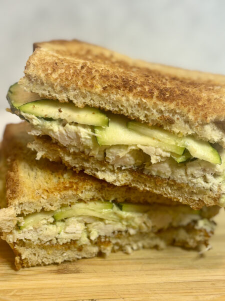 Two halves of a chicken salad sandwich for toddlers are stacked on top of one another.