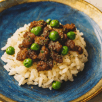 An image of a novel toddler ground beef recipe, here a donburi of marinated ground beef and peas, set over rice.