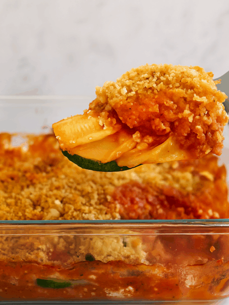 A square of zucchini parmesan for toddlers is lifting out of its baking dish.