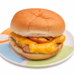 A cheddar apple turkey burger for kids is shown on a colorful plate.