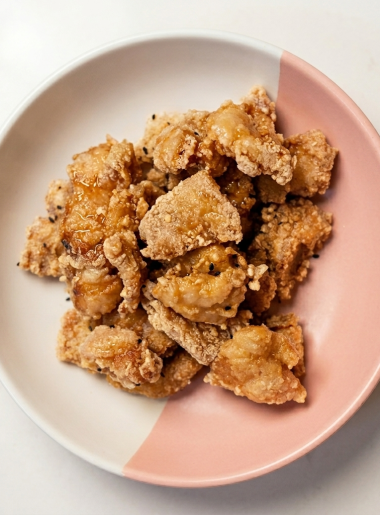 A stack of kaarage fish nuggets are shown stacked upon one another in a pink and white bowl.