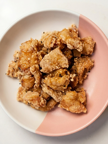 A stack of kaarage fish nuggets are shown stacked upon one another in a pink and white bowl.