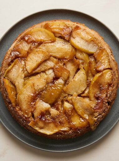 Overhead shot of a full apple upside down cake, with slices of caramelized apple slices dotting the top.